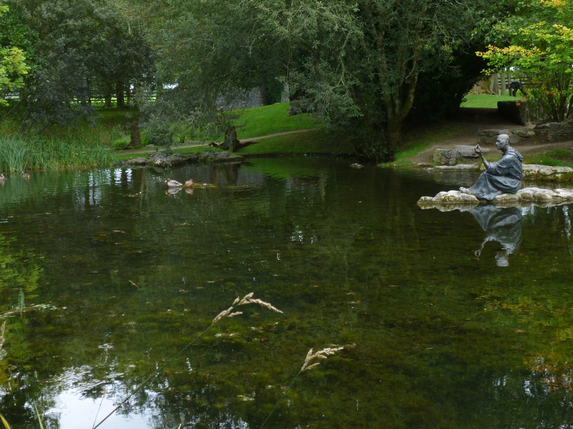 Statue méditative près d'un étang dans un jardin